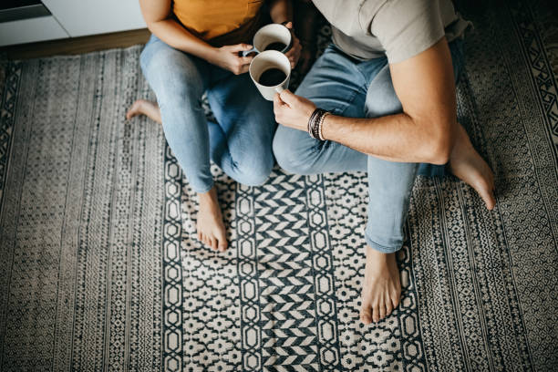 Couple drinking coffee sitting on area rug | Great Floors