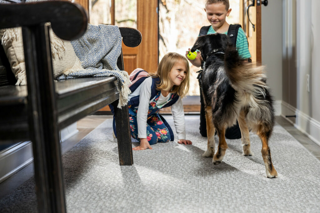 Kids plying with dog on carpet flooring | Great Floors