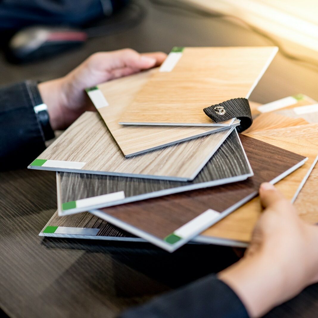 Asian architect man choosing wooden color swatch Flooring samples at home | Great Floors